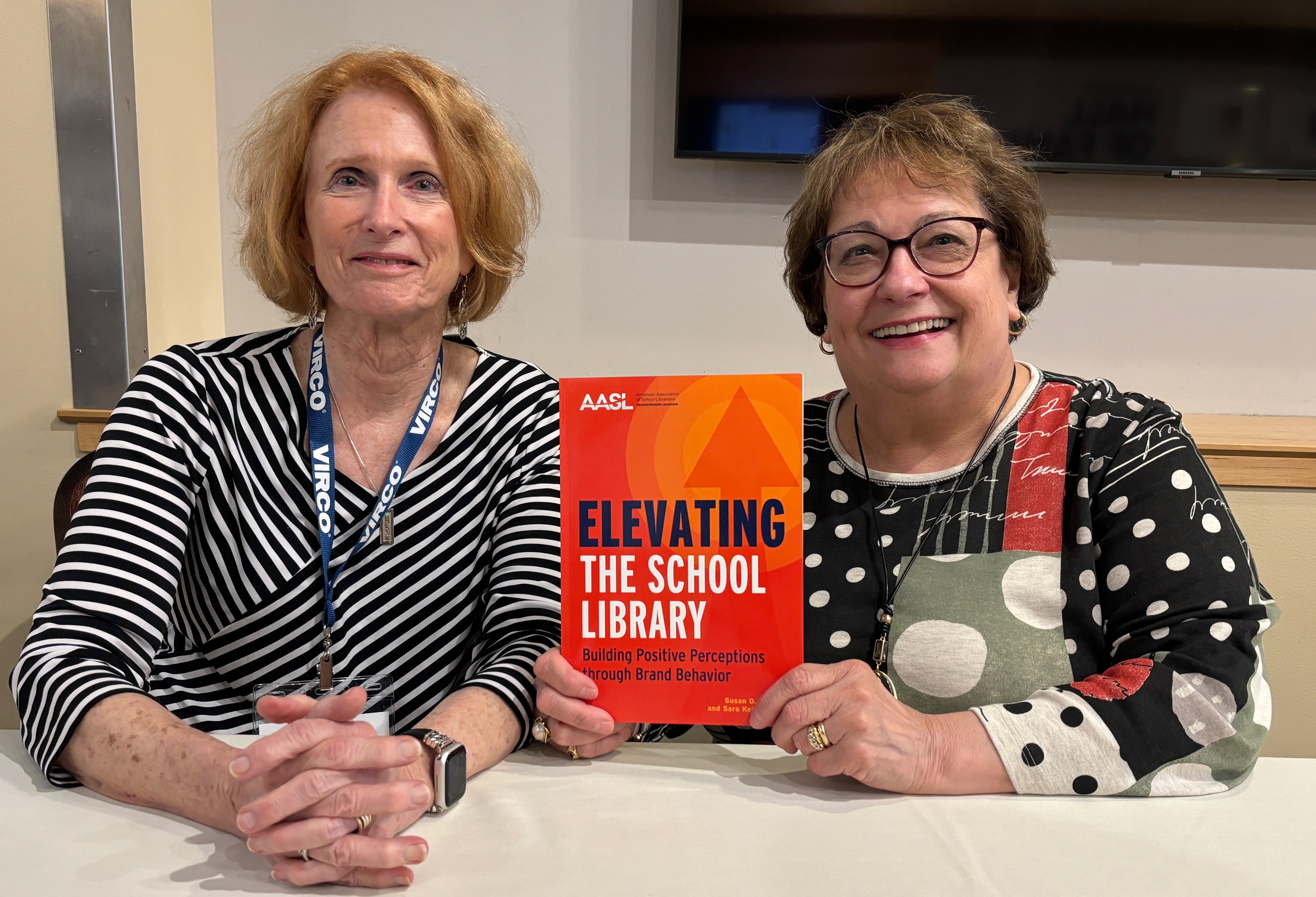 two women holding book